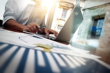 business documents on office table with smart phone and digital tablet and graph financial diagram and man working in the background-1